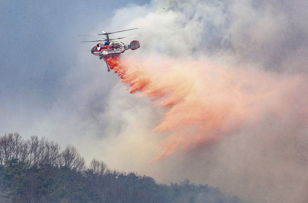 Un helicóptero del Servicio Forestal de Corea arroja retardante de incendios sobre un incendio forestal en Uiseong, Corea del Sur, lunes 24 de marzo de 2025