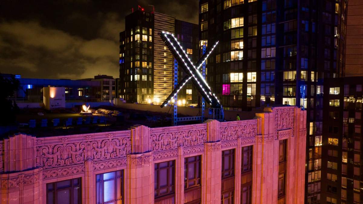 Varios trabajadores instalan la iluminación de un letrero de "X" sobre las oficinas generales de la empresa, anteriormente conocida como Twitter, en el centro de San Francisco