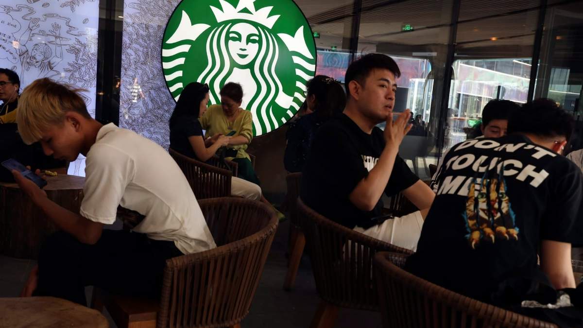 Clientes disfrutan de sus bebidas en una cafetería Starbucks, el 10 de mayo de 2019, en Beijing