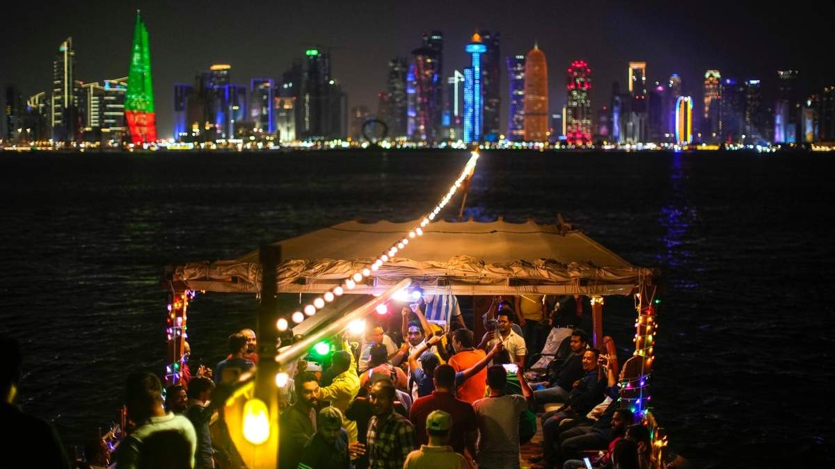 La gente baila en un bote de madera en el paseo marítimo Corniche en Doha, Qatar