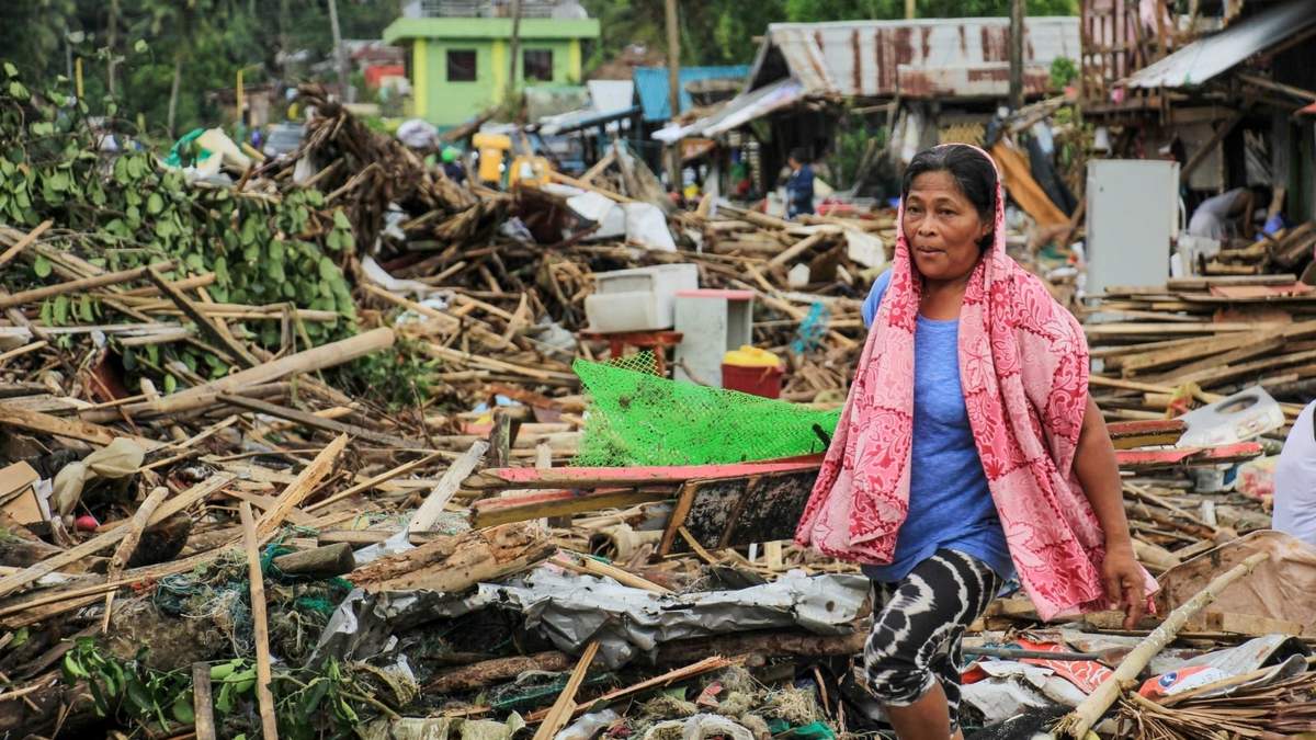 Una mujer en Filipinas camina sobre los escombros de una urbanización. Fuente: (Twitter)