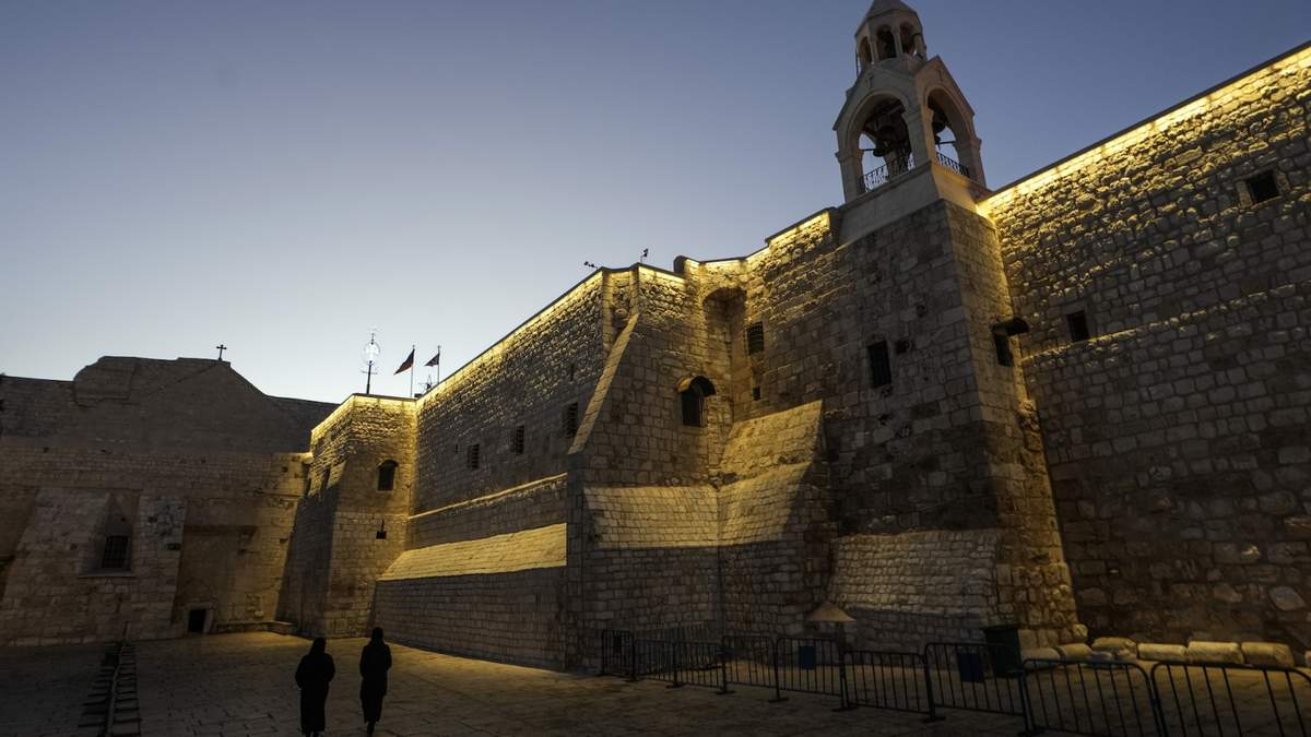 Unas monjas caminan junto a la Iglesia de la Natividad, tradicionalmente considerada el lugar de nacimiento de Jesús, en la Víspera de Navidad, en la ciudad cisjordana de Belén