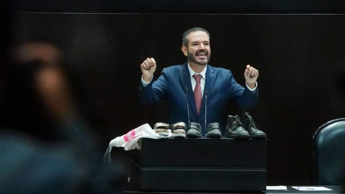 El diputado panista Miguel Ángel Monraz muestra zapatos en alusión al caso Teuchitlán durante la discusión de la Ley de Seguridad