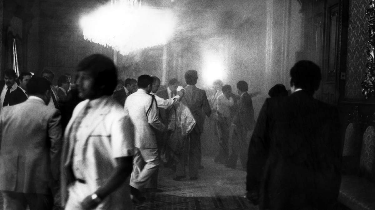 Personas se resguardan en el interior de Palacio Nacional, luego que una segunda bomba molotov explotara, durante el desfile del Día del Trabajo.