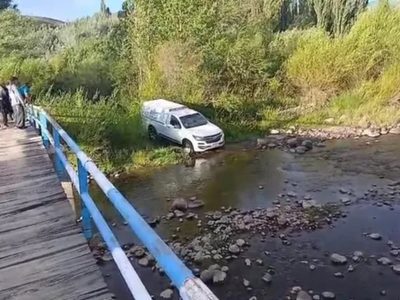 Los Guañacos: una camioneta fúnebre debió atravezar el cauce del río porque está roto el puente