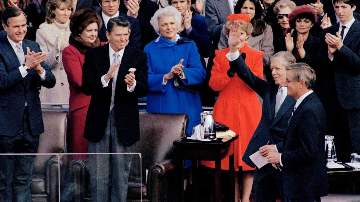El presidente electo Ronald Reagan aplaude mientras el presidente saliente Jimmy Carter saluda a la multitud en la ceremonia de investidura de Reagan, en Washington, el 20 de enero de 1981