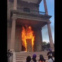 Prenden fuego a puerta del Palacio de Gobierno de NL en protesta por feminicidios (Videos)