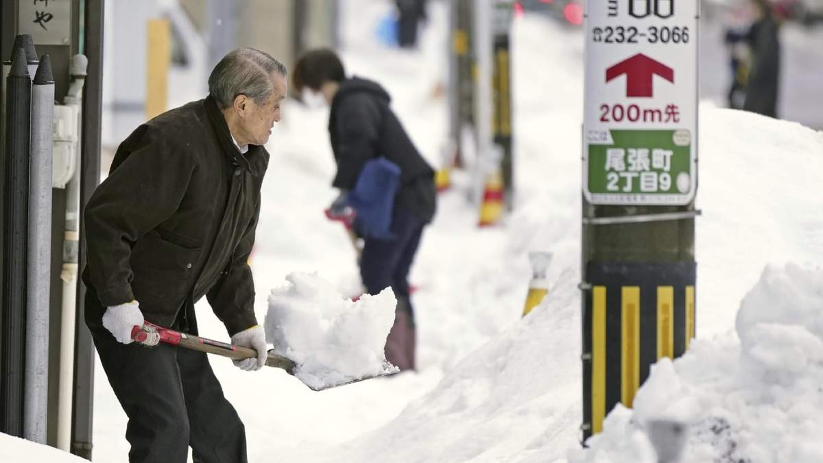 Personas retiran con palas la nieve de las aceras en Kanazawa, en la prefectura de Ishikawa, en el centro de Japón
