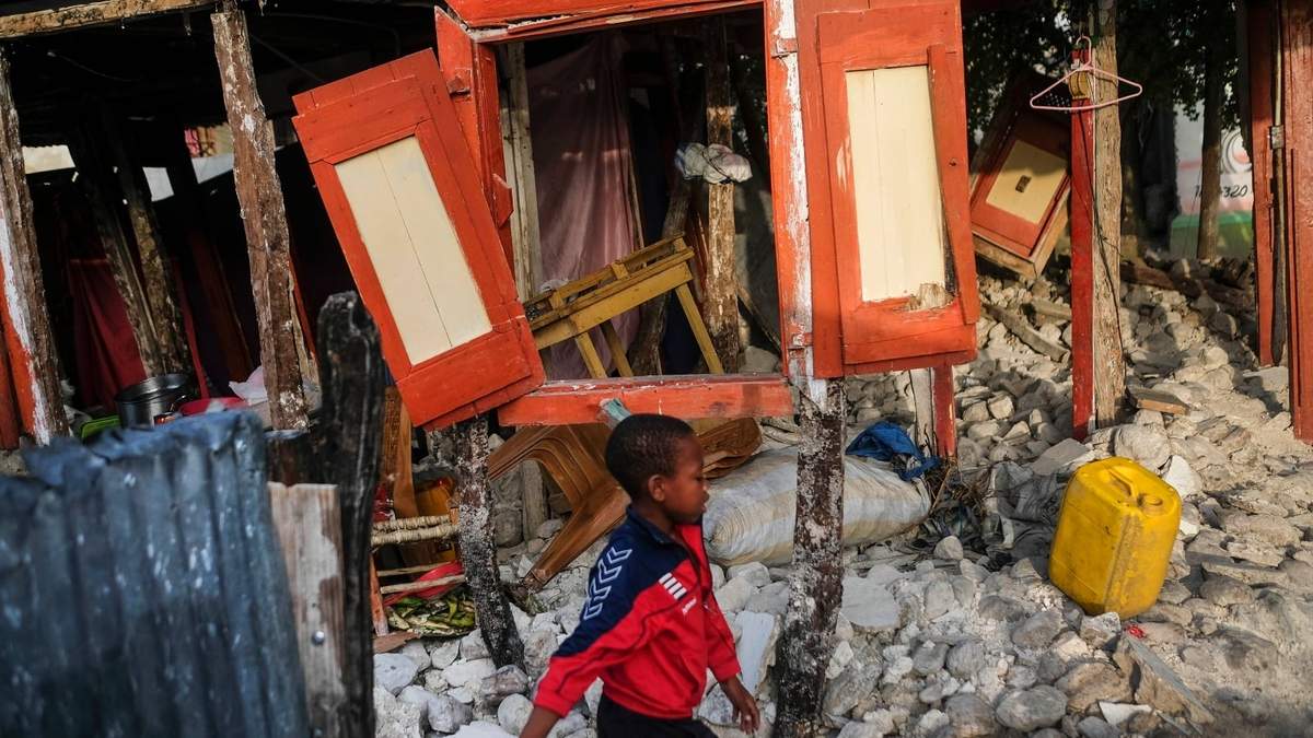Un niño pasa frente a una vivienda destruida por el sismo en Maniche, Haití
