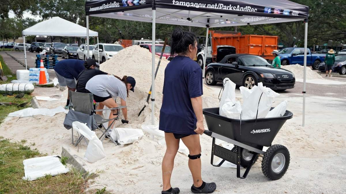 Elementos del Departamento de Parques y Recreación de Tampa, Florida, entregan costales de arena a los residentes