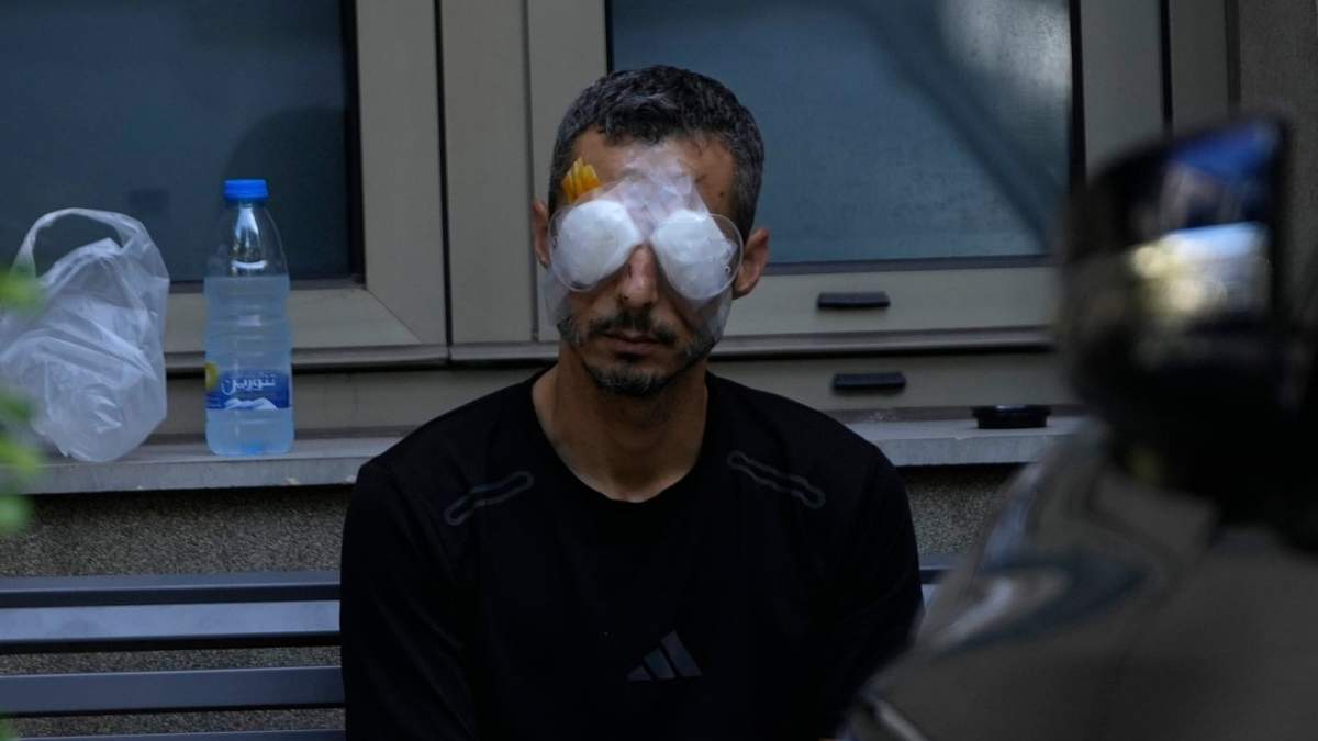 Un hombre que resultó herido en la explosión de uno de los dispositivos portátiles se sienta afuera del hospital Eye Specialist, en Beirut, Líbano