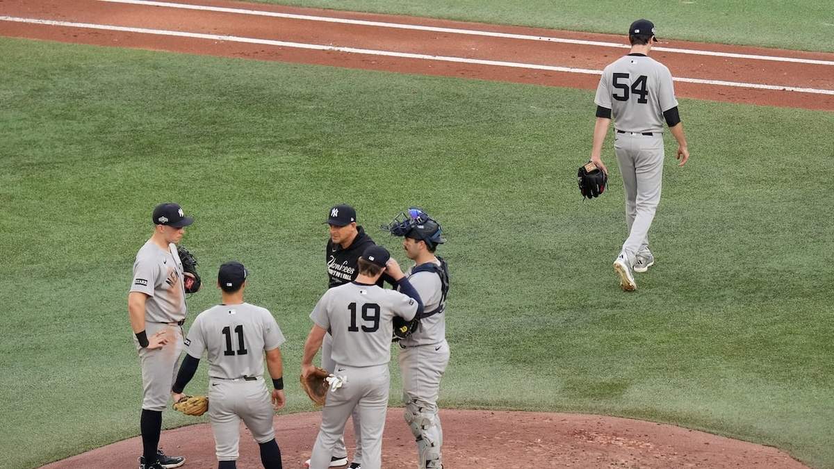 Max Fried (54), lanzador de los Yankees de Nueva York, regresa al dugout después de haber sido retirado de la loma por el manager Aaron Boone