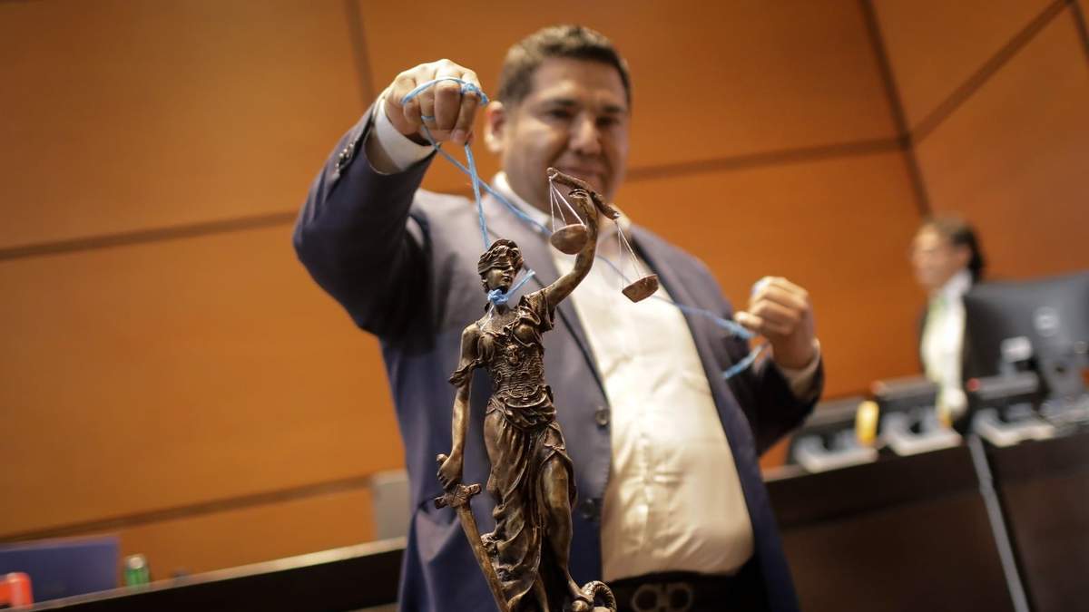 El diputado priísta Eduardo Zarzosa mostró durante la sesión una estatua de la justicia amarrada con un lazo, como metáfora de lo que Morena pretende con la reforma judicial