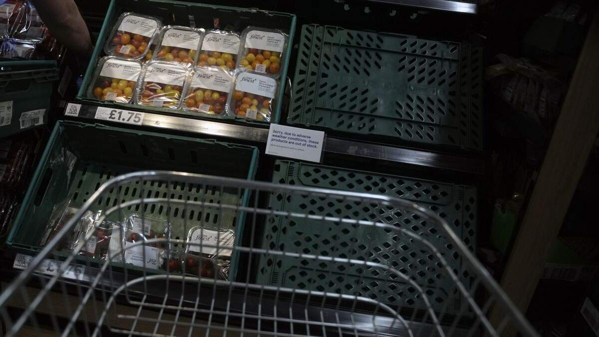 Paquetes de tomates en exhibición al lado de un anuncio que señala que hay una escasez de ellos debido al mal tiempo en el lugar donde se cosechan, en un supermercado de Londres