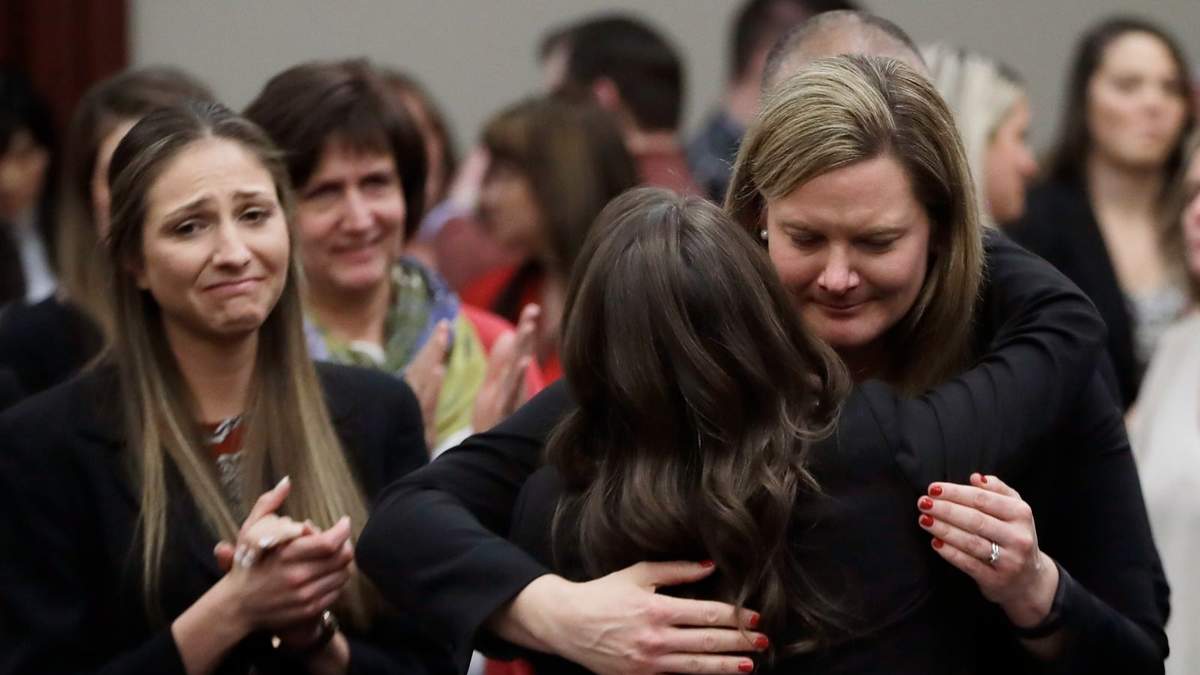 En esta foto del 24 de enero de 2018, las víctimas reaccionan y se abrazan con la fiscal adjunta Angela Povilaitis, luego que el doctor Larry Nassar fuera sentenciado