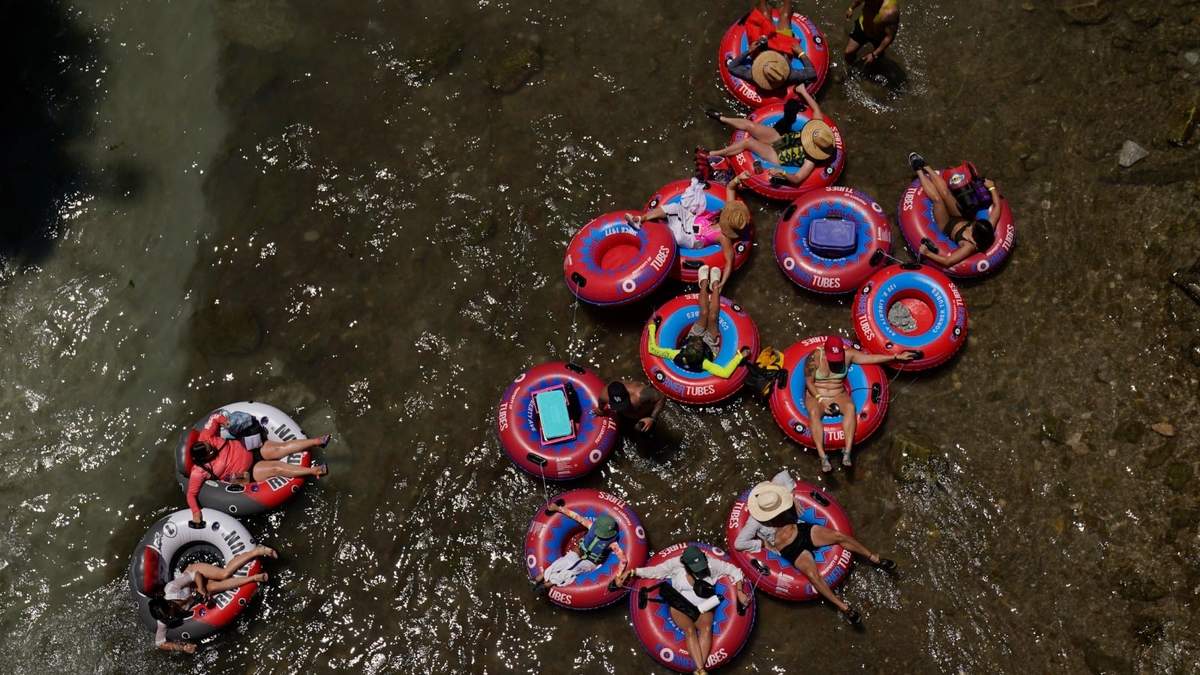 Bañistas en llantas inflables flotan en el frío río Comal, el jueves 29 de junio de 2023, en New Braunfels, Texas