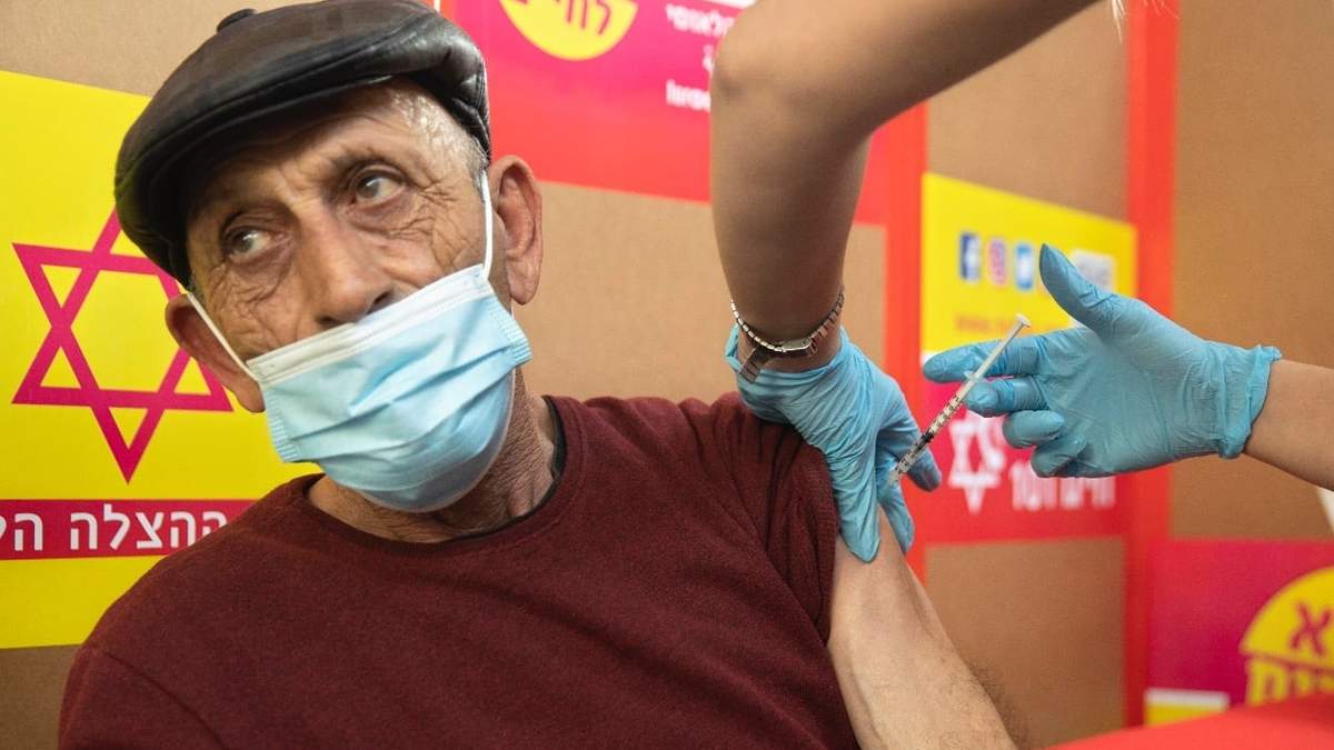 Un palestino que trabaja en Israel recibe una vacuna Moderna covid-19 en el cruce de Tarkumiya entre Cisjordania e Israel