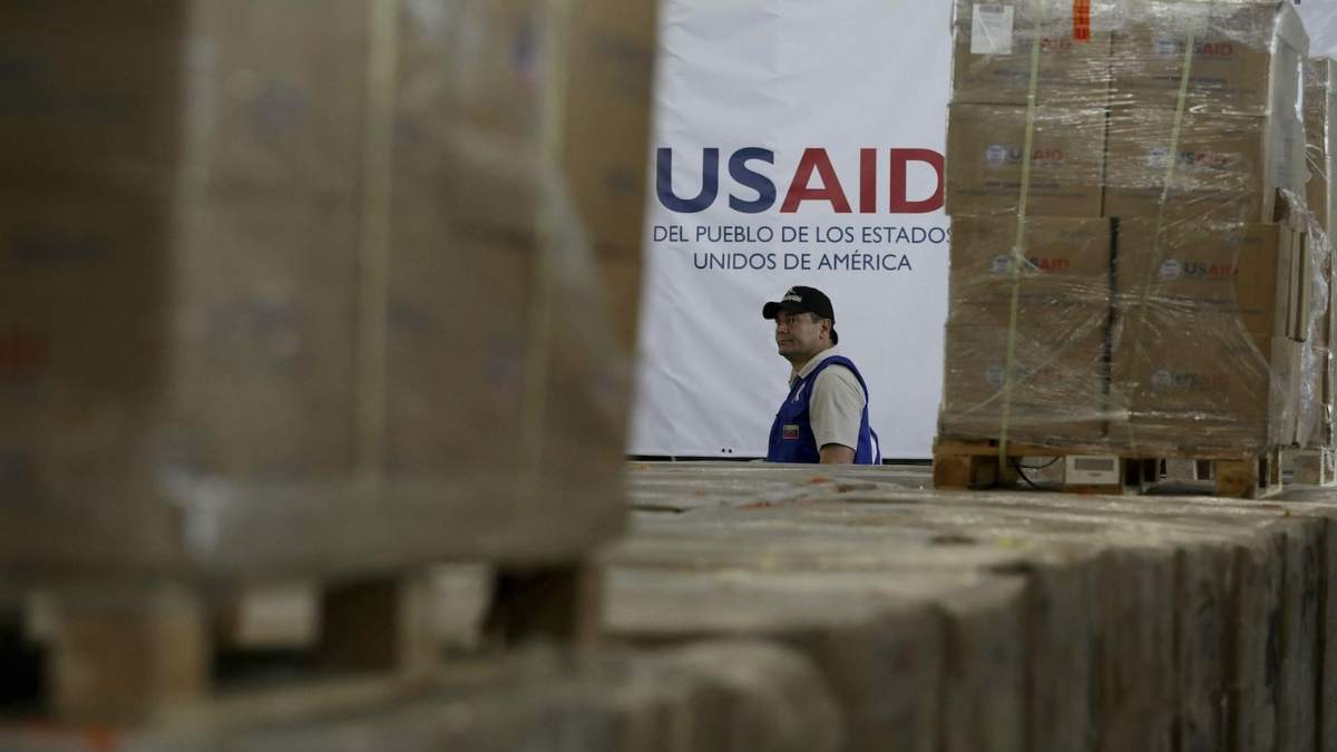 Un hombre pasa frente a cajas de ayuda humanitaria de USAID en un almacén en las afueras de Cúcuta, Colombia, en 2019