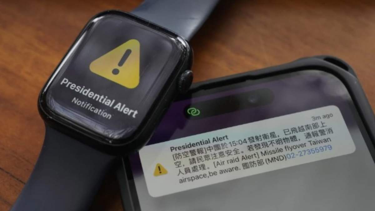 Un celular y un reloj con una alerta antiaérea en sus pantallas, juntos en una foto en Taipéi, Taiwán