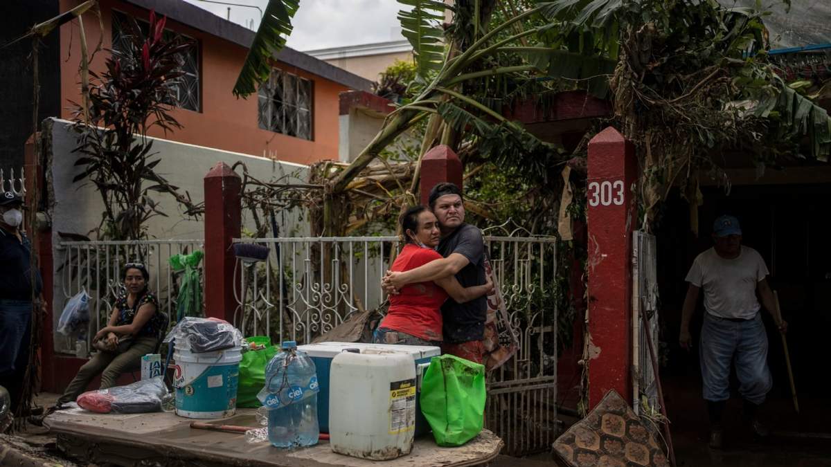 Los lugareños se abrazan frente a una casa inundada en Poza Rica, Veracruz, el domingo 12 de octubre de 2025, tras inundaciones y deslizamientos de tierra