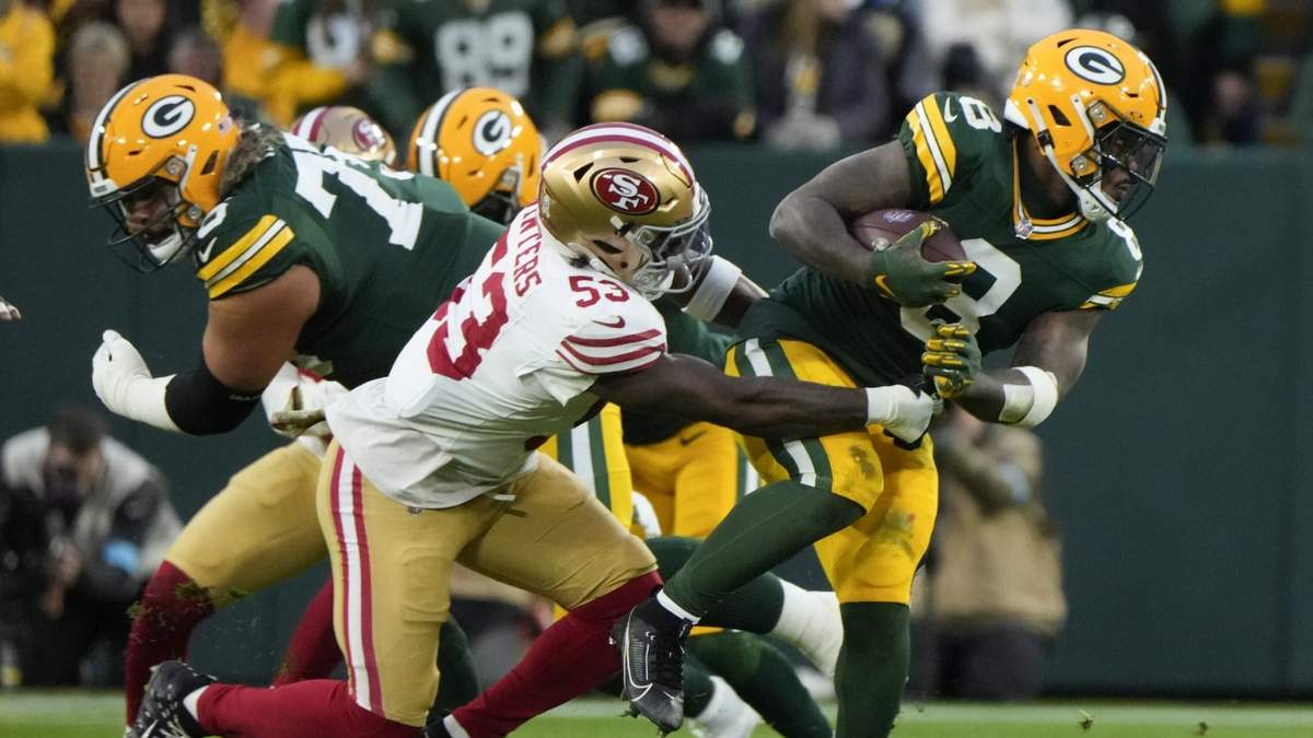 Josh Jacobs (8), running back de los Packers de Green Bay, corre con el balón, e intenta romper un derribo de Dee Winters (53) de San Francisco