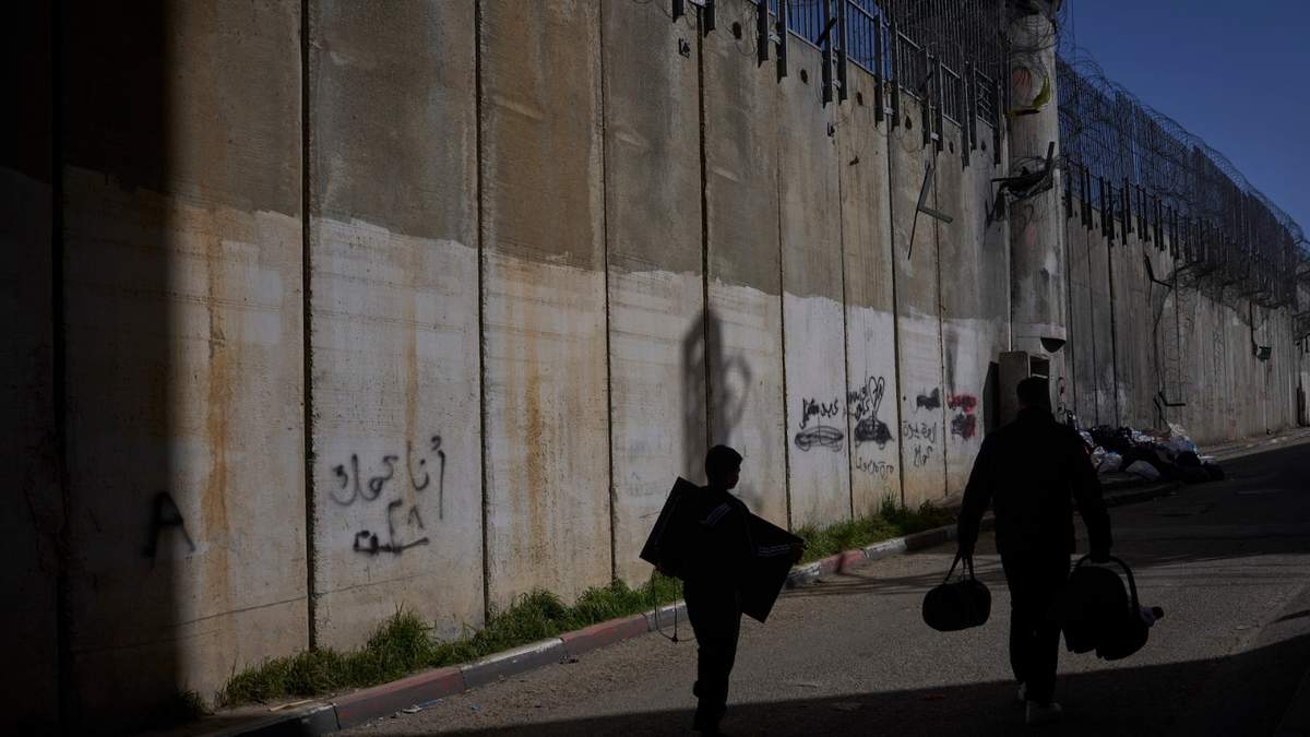 Palestinos caminan a lo largo de la barrera de separación entre Cisjordania y el barrio de Beit Hanina, en Jerusalén Este