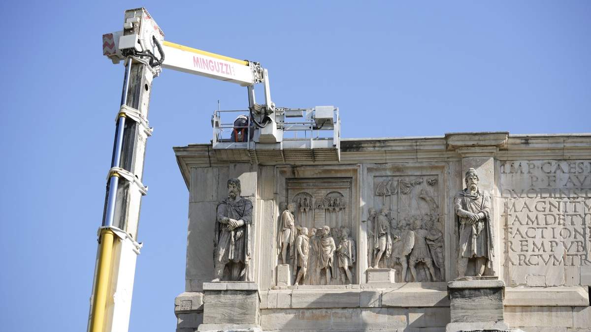 Trabajadores utilizan una grúa para recolocar y asegurar los fragmentos afectados por un rayo en el Arco de Constantino, del 315 d.C., cerca del Coliseo, en Roma