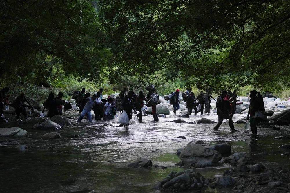 Migrantes cruzan el río Acandi en Colombia, el 15 de septiembre de 2021, mientras continúan su viaje al norte hacia la selva conocida como el Tapón del Darién