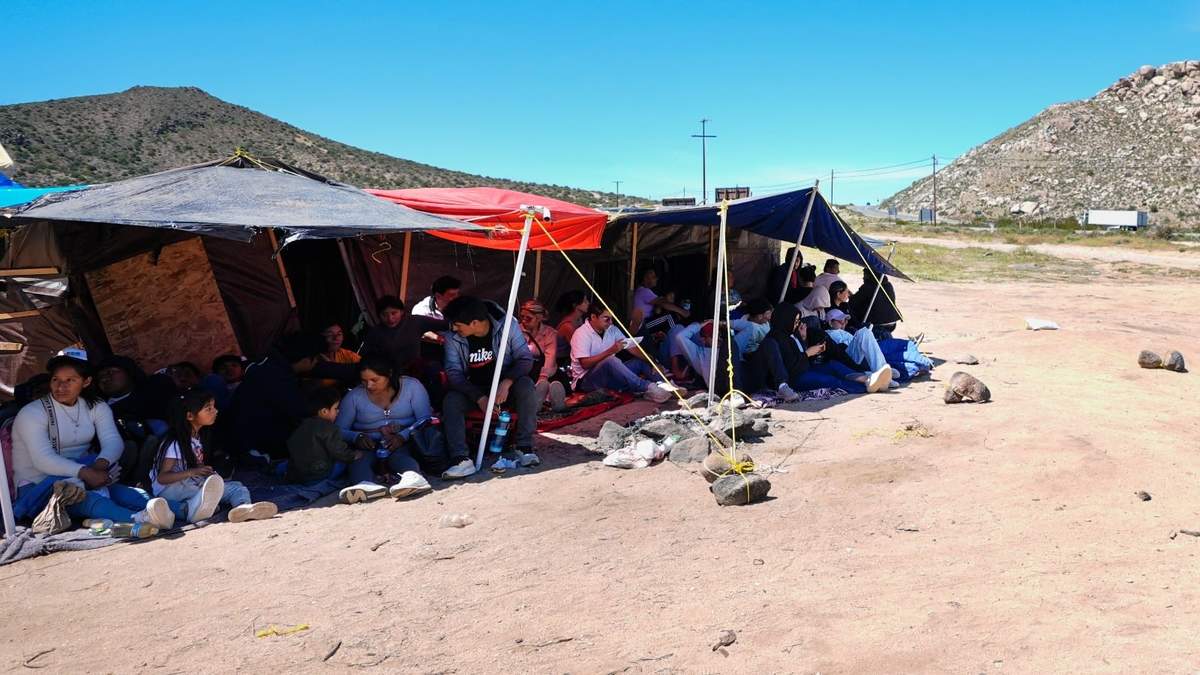 Un grupo de personas esperan a ser procesadas después de cruzar la frontera cerca de Jacumba, California