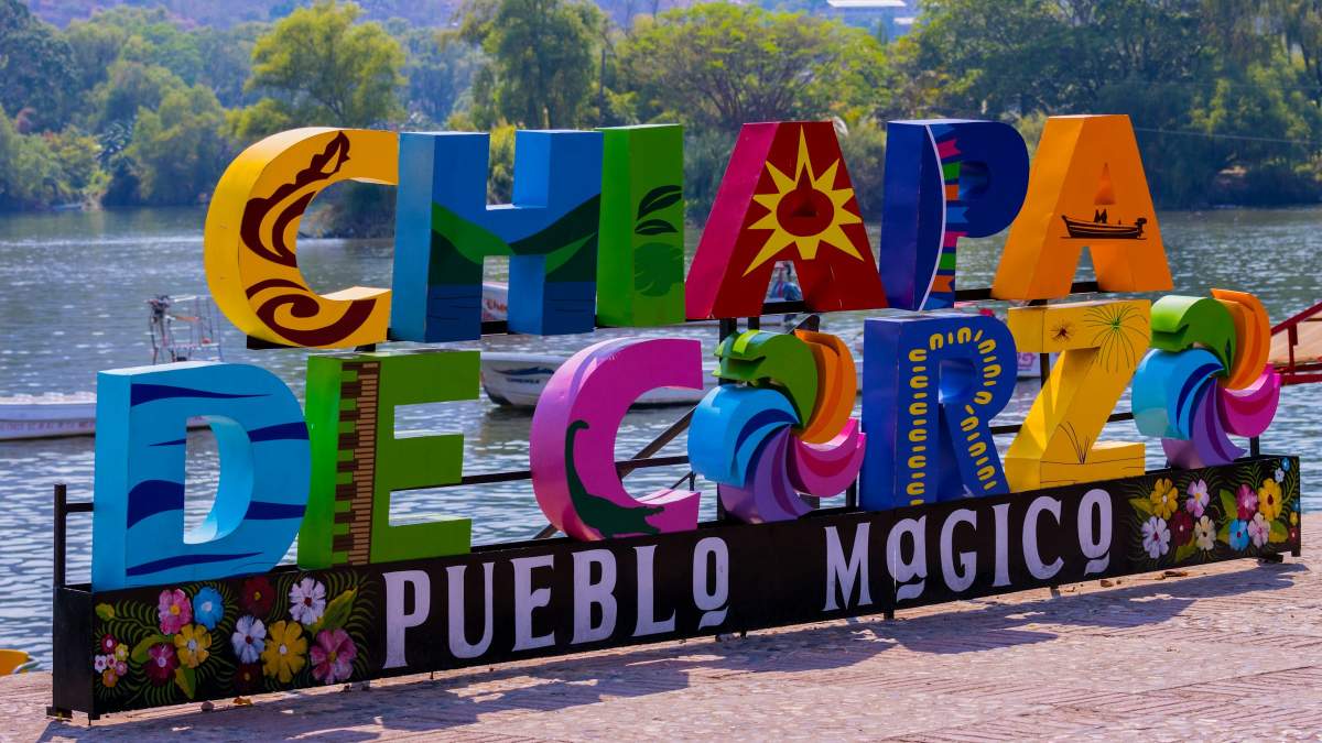 a colorful sign that says happy birthday in front of a body of water