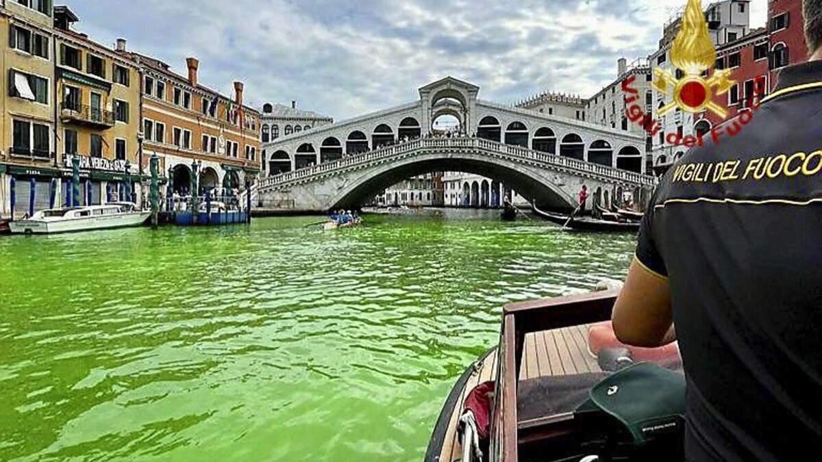 En esta imagen proporcionada por los bomberos italianos, se observa el Gran Canal de Venecia mancho de líquido verde fosforescente, el domingo 28 de mayo de 2023. La policía de Venecia está investigando la fuente del líquido verde