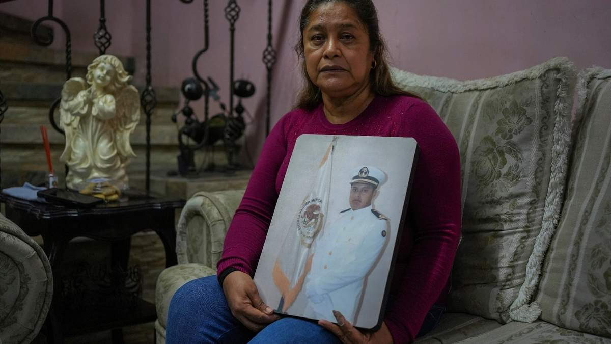María Meza, madre de Arturo Zacarías Meza, muestra una foto de su hijo en su casa en Misantla