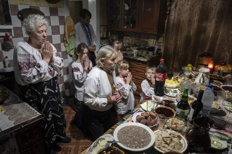 Una familia reza antes de su cena de Navidad en la localidad de Kryvorivnia, Ucrania, el domingo 24 de diciembre de 2023
