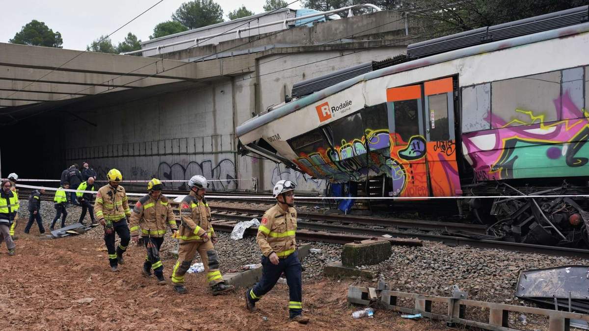 Agentes de la policía y bomberos inspeccionan los daños tras el descarrilamiento de un tren de cercanías a causa de un muro caído sobre la vía, en Gelida, cerca de Barcelona, España