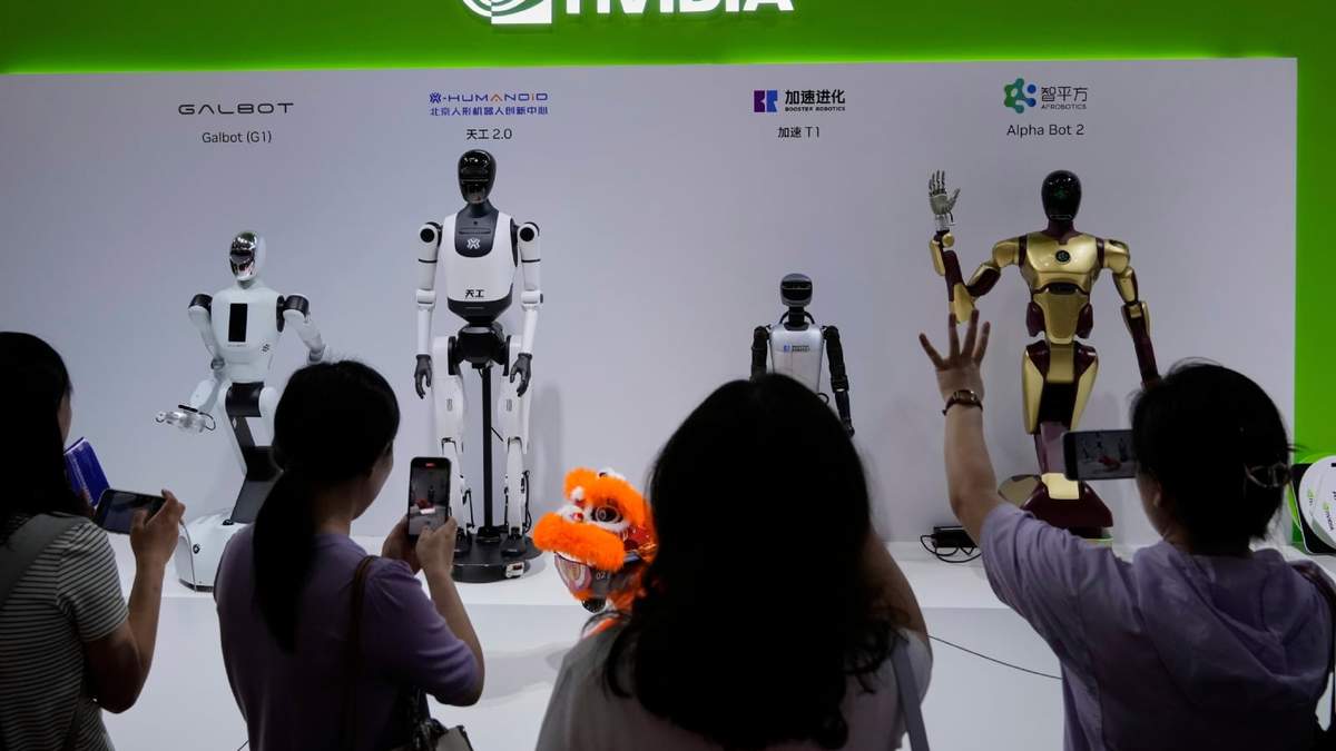 Visitantes dan órdenes a un robot en un puesto de Nvidia durante la 3ra Feria Internacional de China sobre Cadena de Suministro en el China International Exhibition Center, Beijing