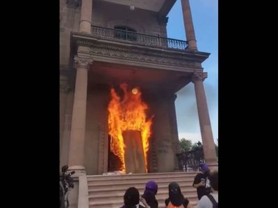 Prenden fuego a puerta del Palacio de Gobierno de NL en protesta por feminicidios (Videos)