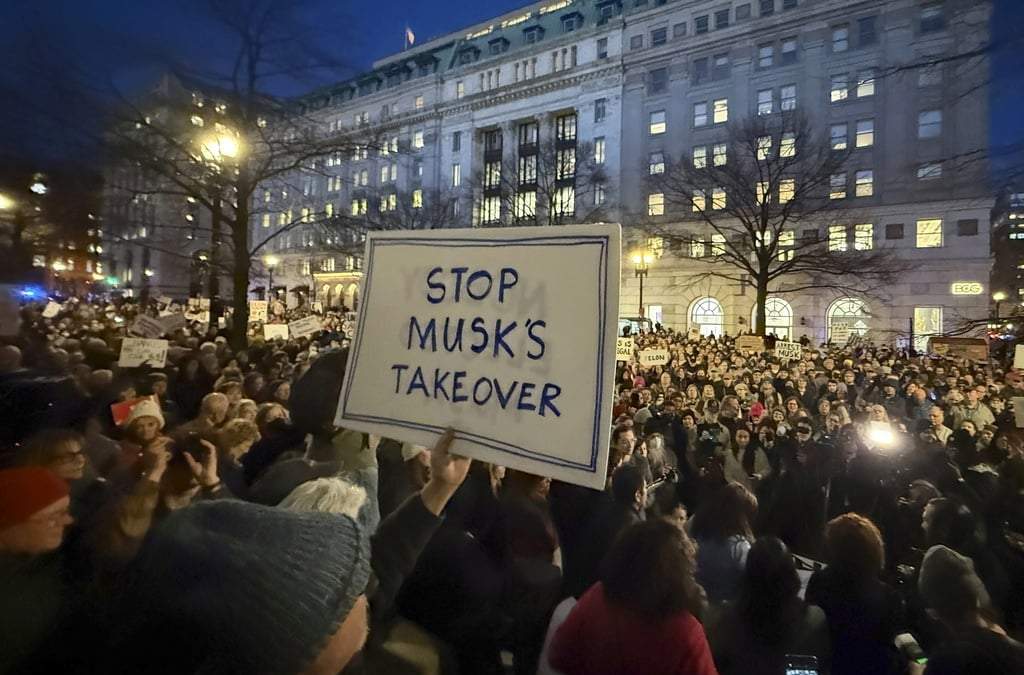 Personas protestan contra Elon Musk durante un mitin afuera del Departamento del Tesoro