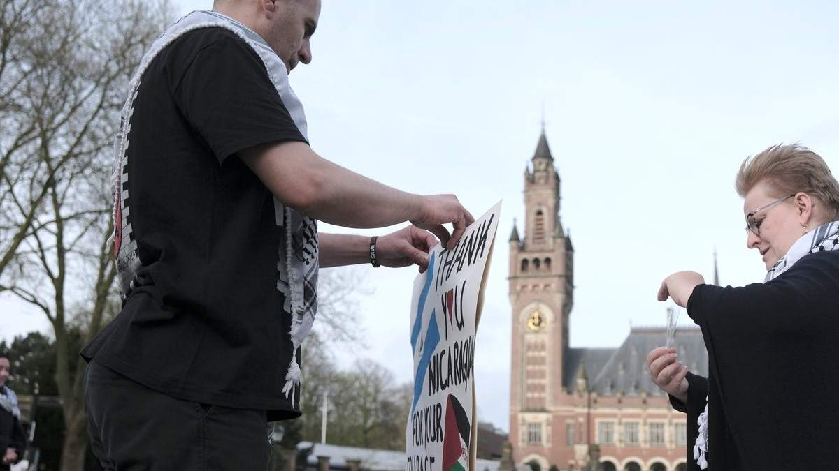 Una activista propalestina prepara un cartel de protesta cerca de la Corte Internacional de Justicia, o Corte Mundial, en La Haya, Holanda, el lunes 8 de abril de 2024, antes del inicio de dos días de sesiones en un caso iniciado por Nicaragua contra Alemania, que fue acusada de incumplir la convención contra el genocidio al proporcionar apoyo y armas a Israel. ()
