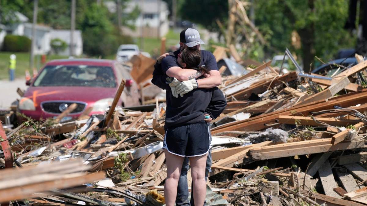 Residentes se abrazan frente a los restos de su casa tras el paso de un tornado en Greenfield, Iowa