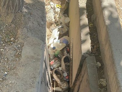 La acequia que está al lado de un hospital y está tapada de basura