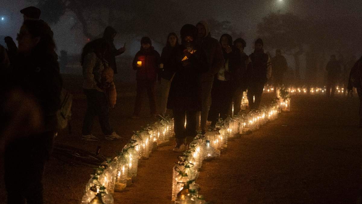 Personas caminan con velas a medianoche en el 50 aniversario del golpe de Estado de 1973