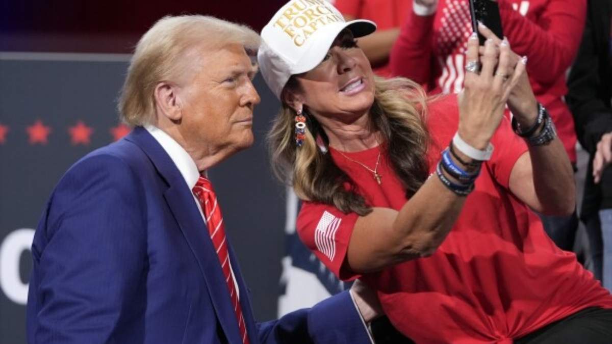 El candidato presidencial republicano Donald Trump posa para una selfie con una seguidora en un evento de campaña