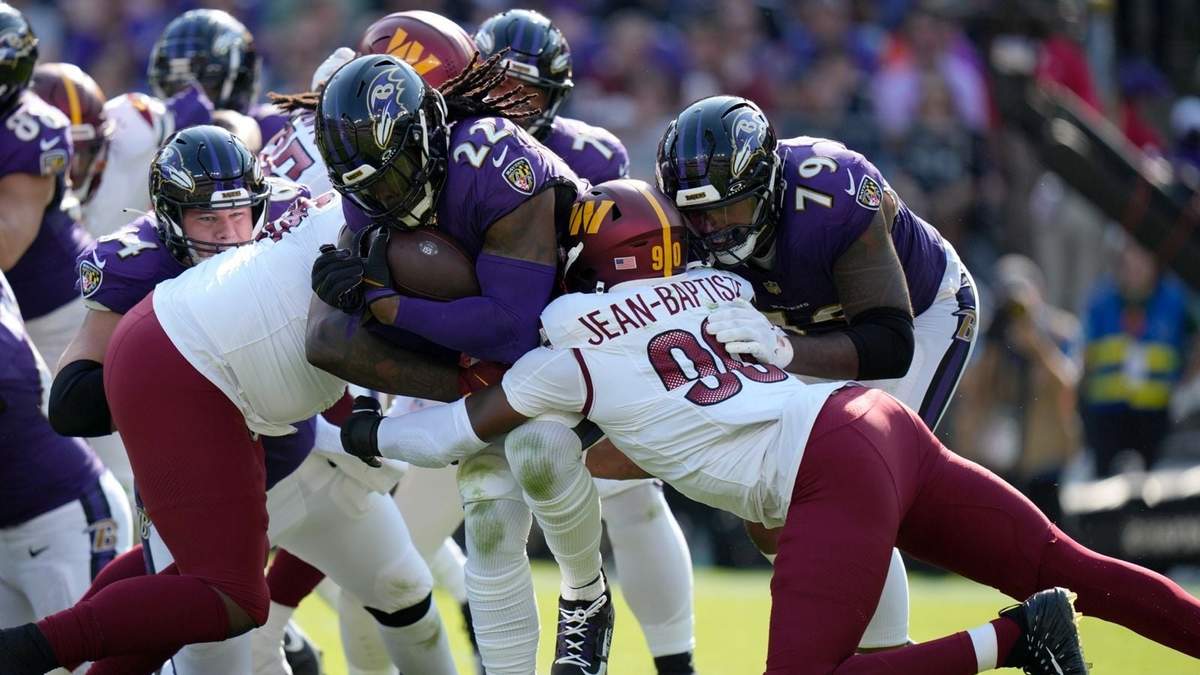Derrick Henry (22), running back de los Ravens de Baltimore, corre con el balón en contra de los Commanders de Washington, con Javontae Jean-Baptiste (90) tratando de detenerlo durante la segunda mitad del partido de la NFL, el domingo 13 de octubre de 2024