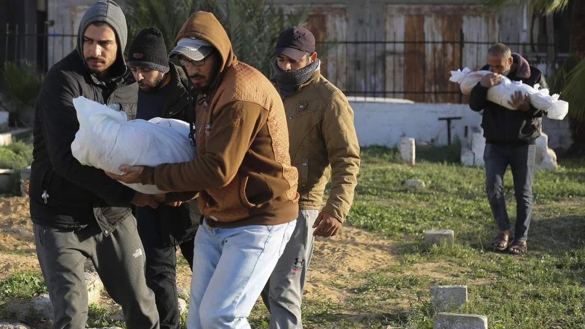 Palestinos cargan los cuerpos de los miembros de una familia en Dhair que murieron en un bombardeo en la Franja de Gaza