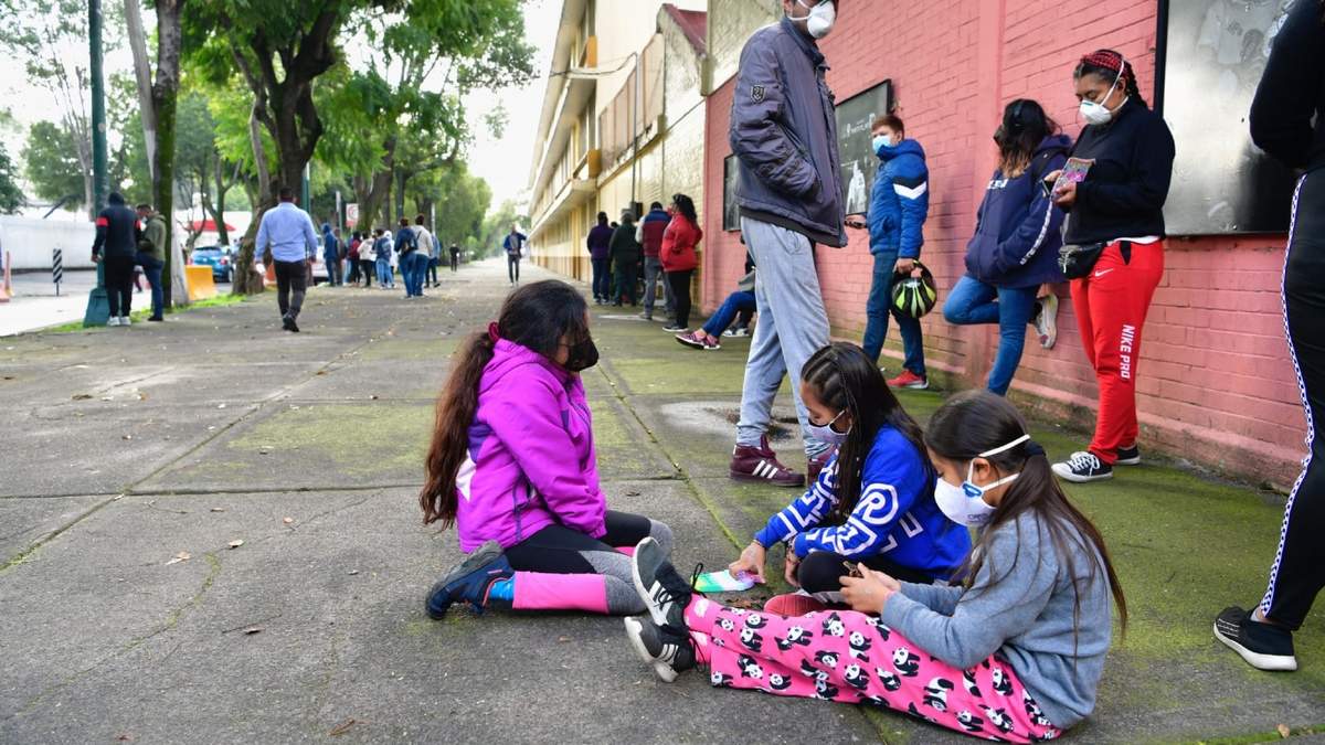 Menores de 18 años hacen fila afuera de un módulo de pruebas covid