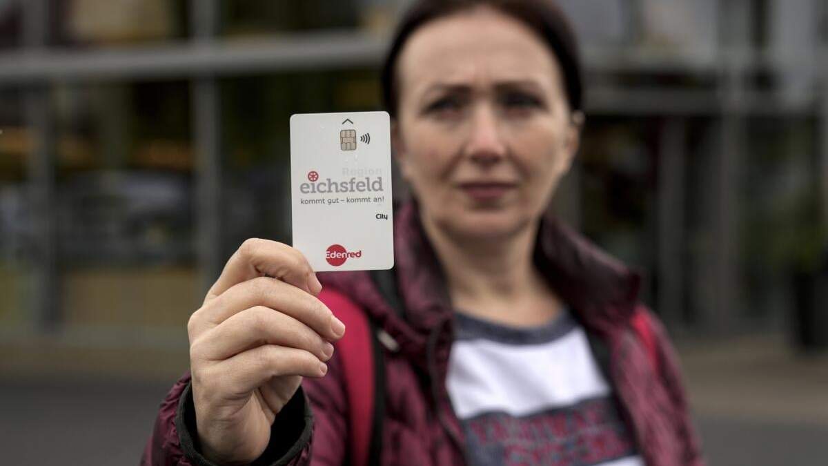 Erdina Laca, una solicitante de asilo de 45 años, muestra una tarjeta de pago especial del gobierno para dar subsidios a migrantes, en Eichsfeld, Alemania