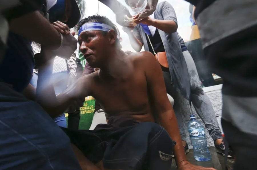 Un manifestante herido recibe primeros auxilios después de ser herido por un disparo de escopeta durante enfrentamientos con la policía en 2018