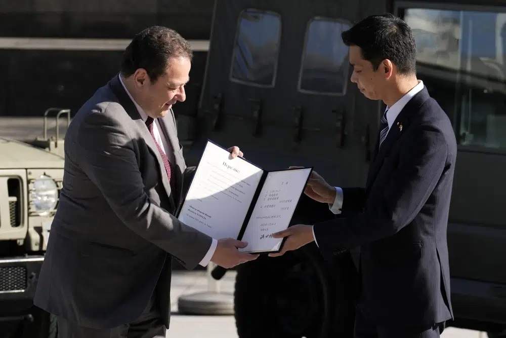 El embajador de Ucrania en Japón, Sergiy Korsunsky, recibe un documento del viceministro de Defensa, Toshiro Ino, durante la entrega de equipo de defensa para Ucrania el  24 de mayo de 2023