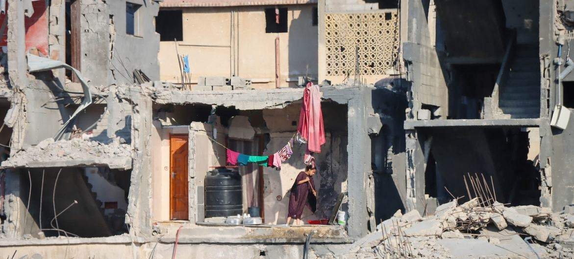 Una mujer limpia el suelo de un edificio destruido en Gaza.
