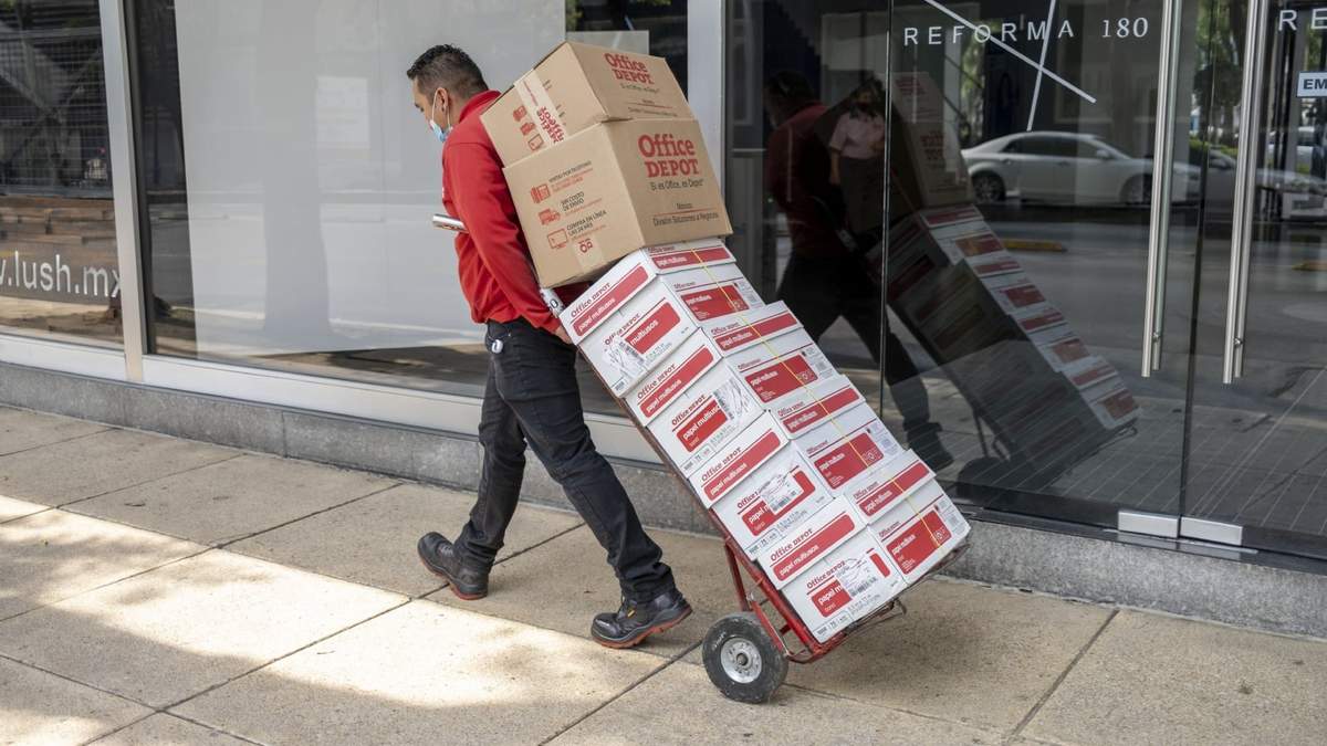 Un hombre traslada cajas de papel